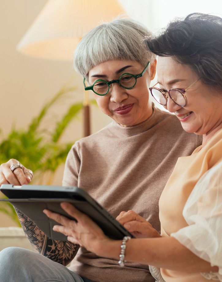 Woman teaching older woman technology