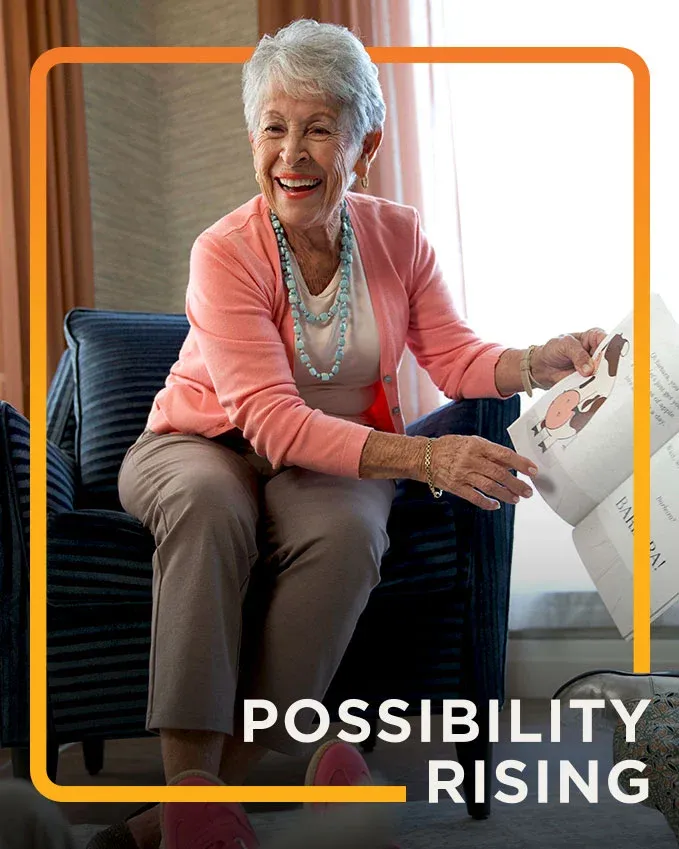 senior living resident reading a book to children