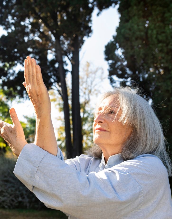 Senior woman practicing tai chi outside