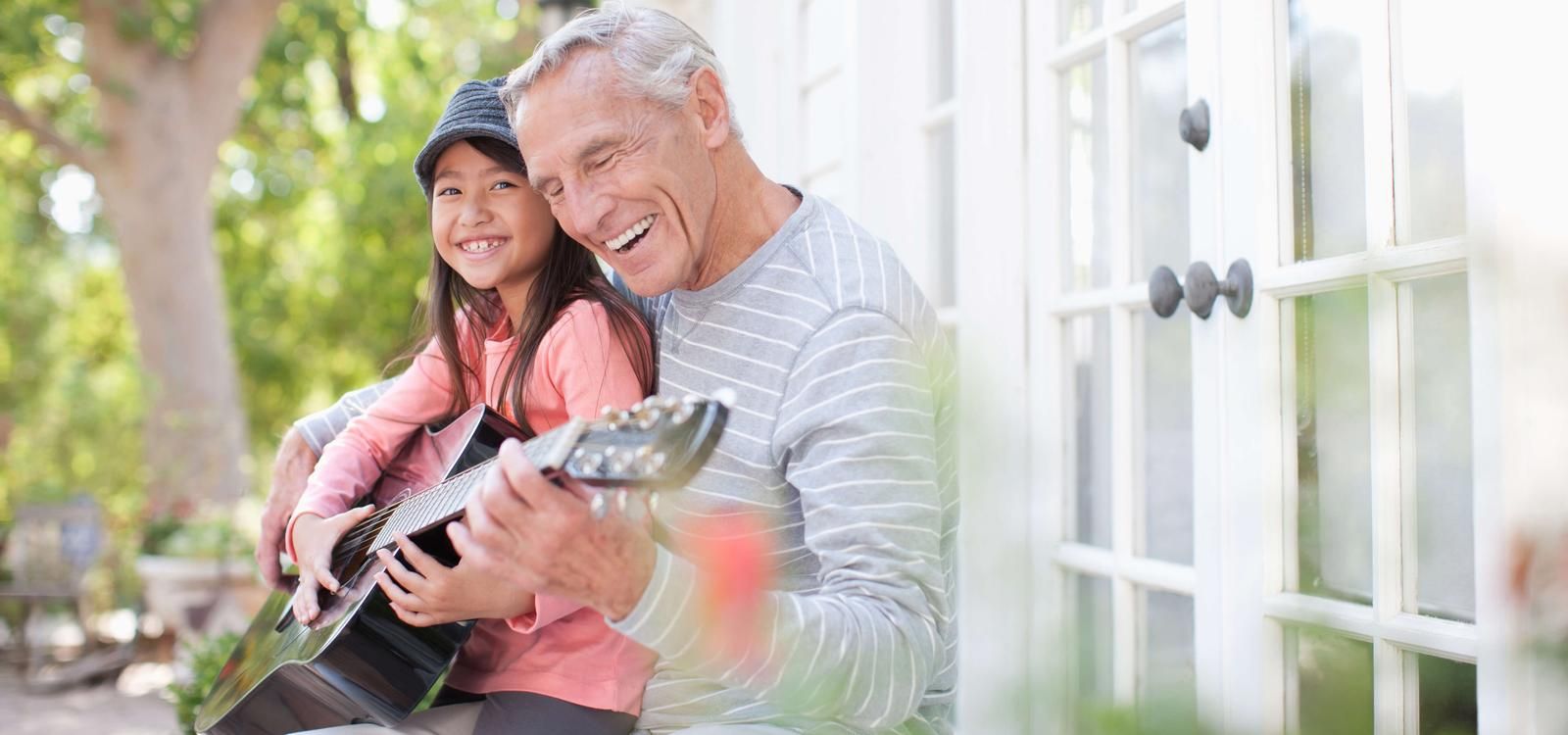 Grandpa and granddaughter playing guitar