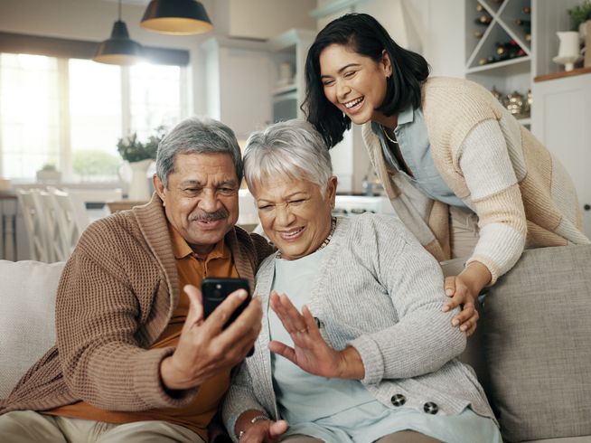 Senior parents and daughter talking on a smartphone.