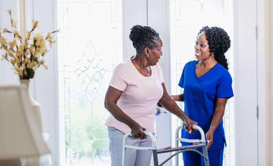 Nurse and senior woman using walker