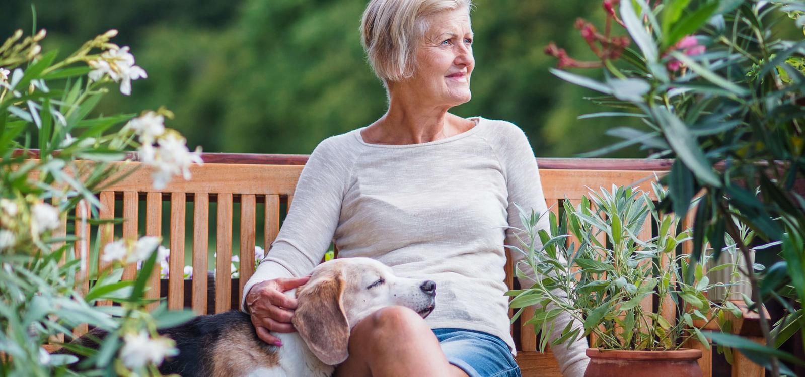 Female resident sitting on bench with dog