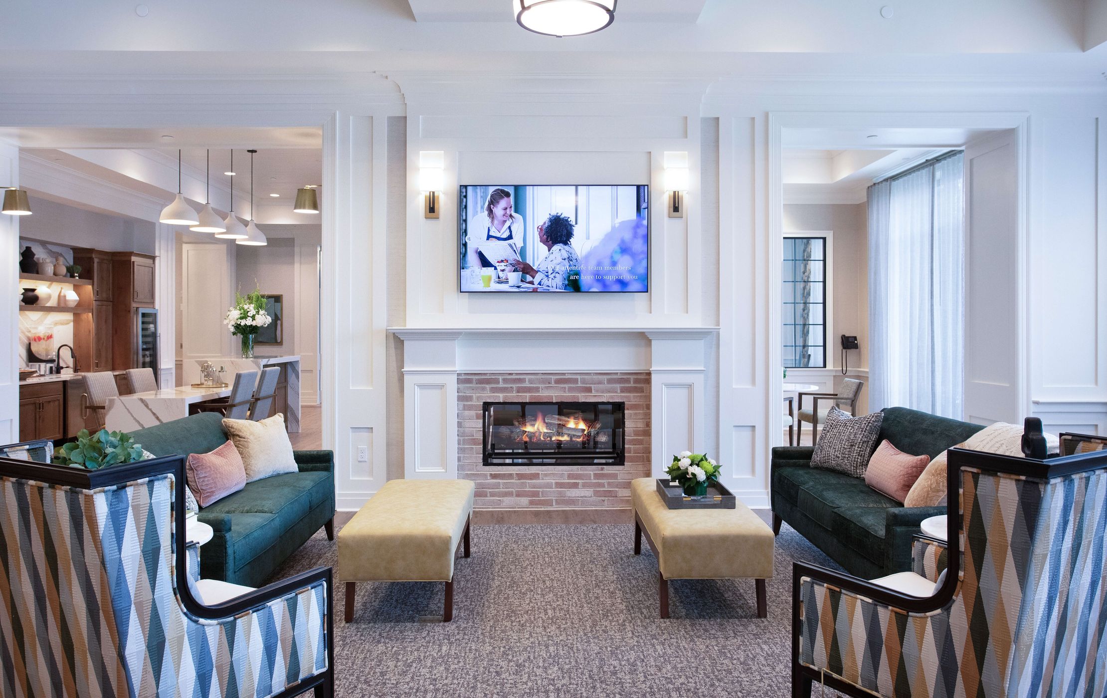 Cozy living room in an assisted living residence with a fireplace, television and couches