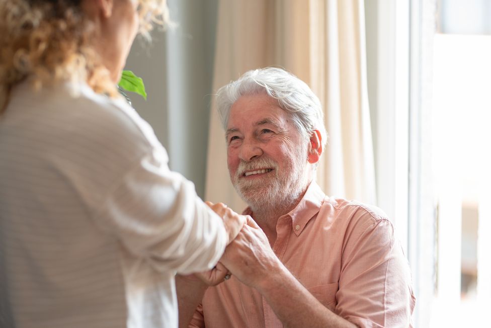 Senior man holding hands with caregiver