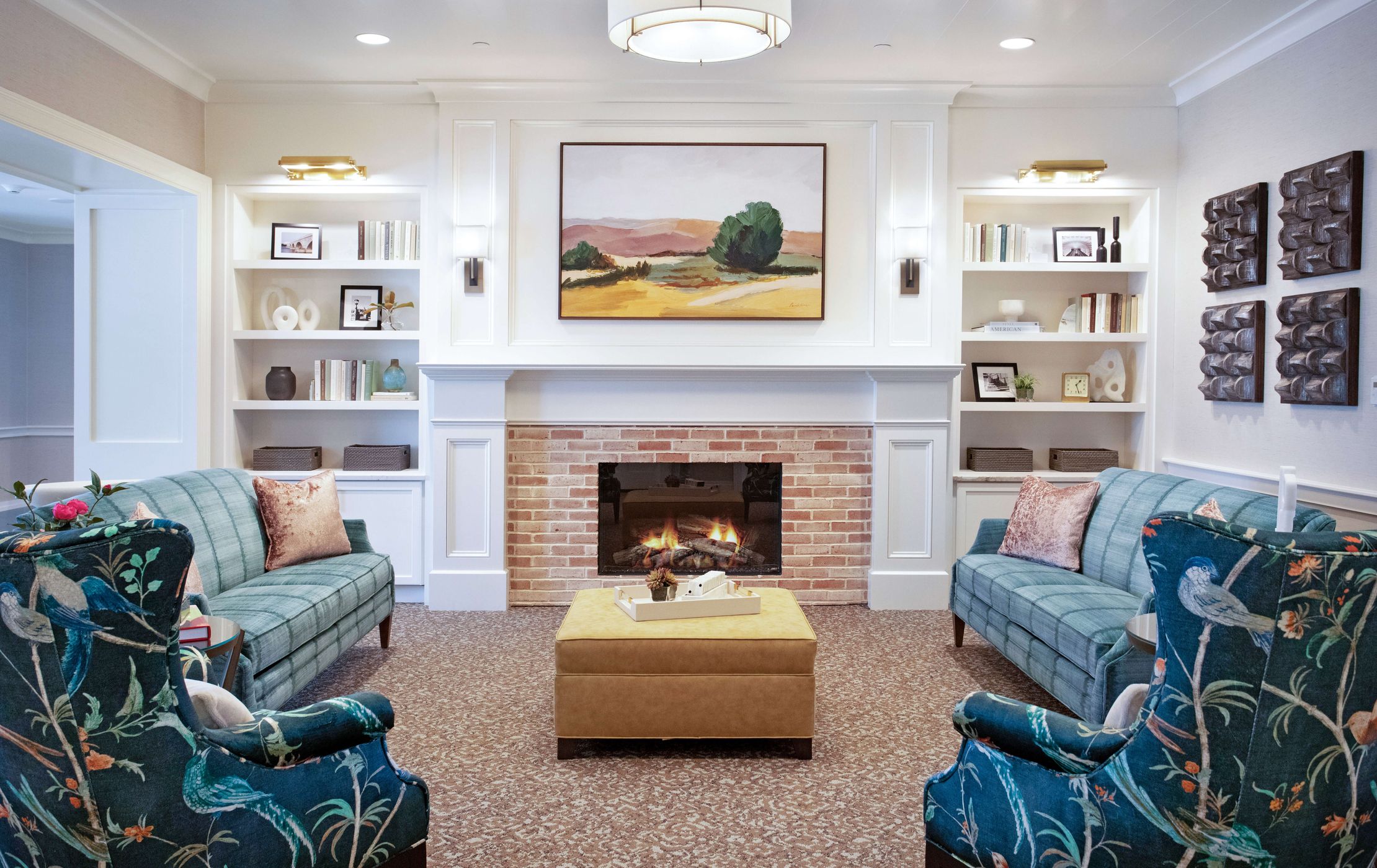 Living area at Senior Living Community with loveseats, couches, and a fireplace for residents