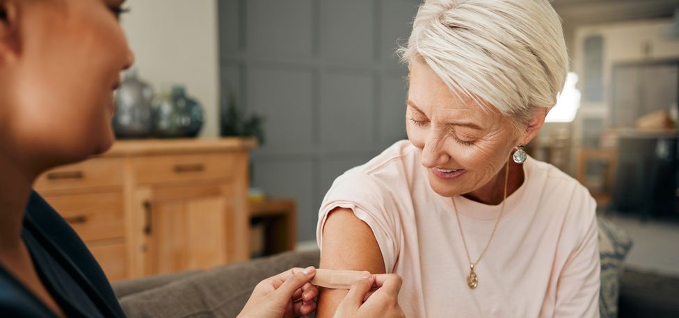 Senior woman receiving a bandage after a vaccine