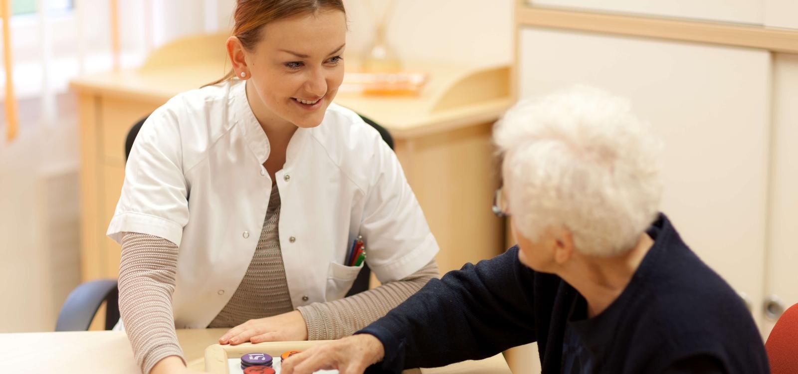 Care taker and resident playing a memory game