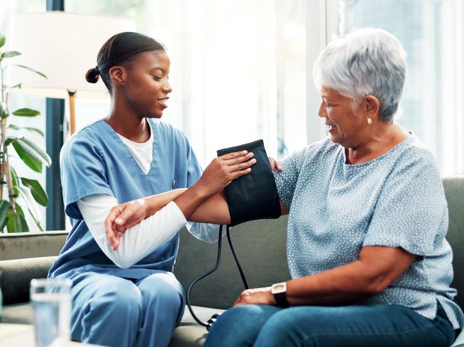 Senior woman getting her blood pressure measured by a nurse.