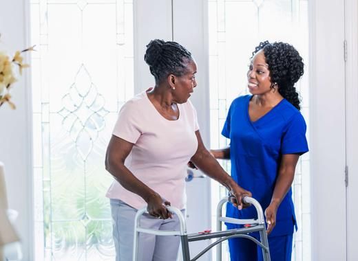 Nurse and senior woman using walker