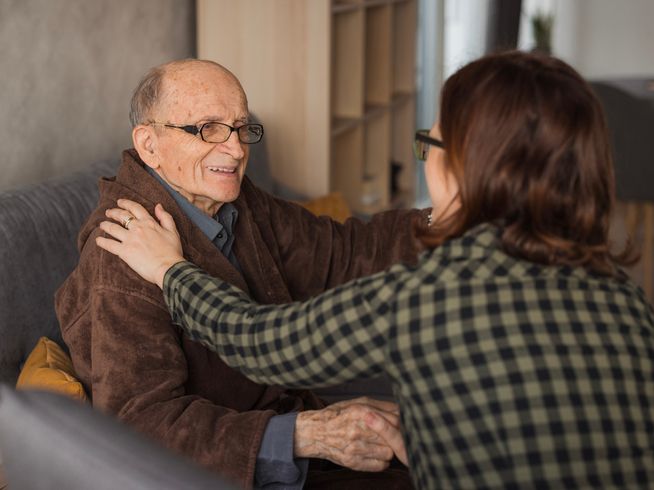 Senior man receiving care from daughter
