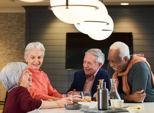 Residents laughing at a Social Hour in the Bistro at Sunrise Senior Living