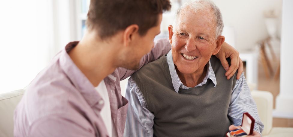 Senior Veteran showing a medal to his son