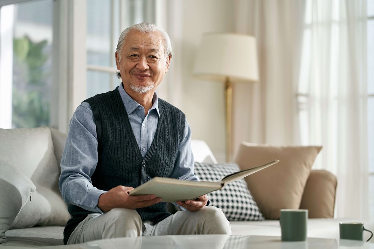 Male resident reading a book in his apartment