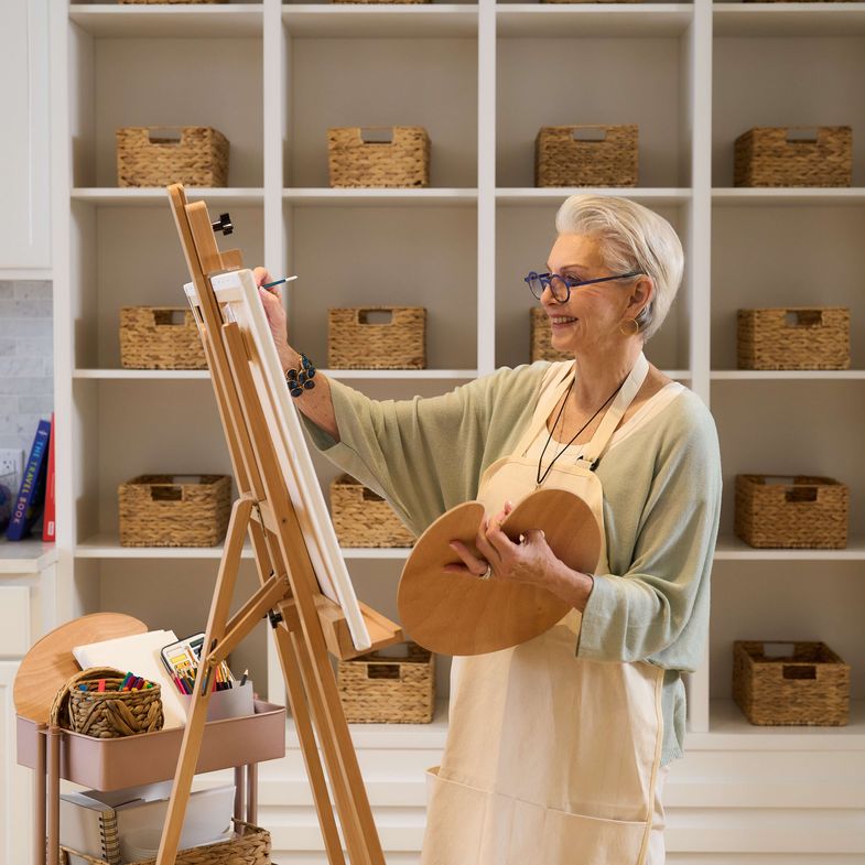 Happy resident painting on a canvas in an art studio at Sunrise Senior Living