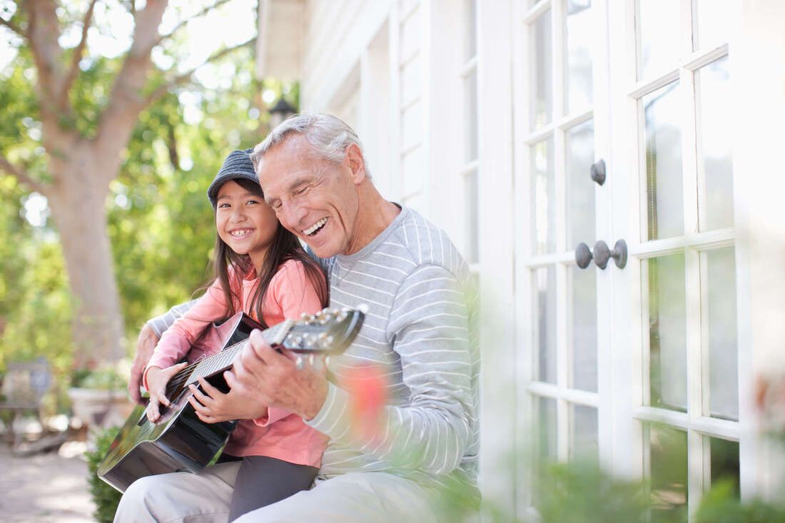 Grandpa and granddaughter playing guitar