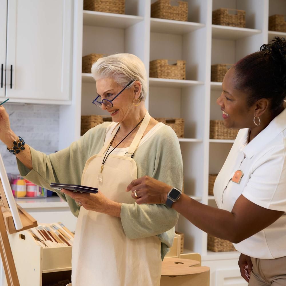 Resident painting with Team Member.