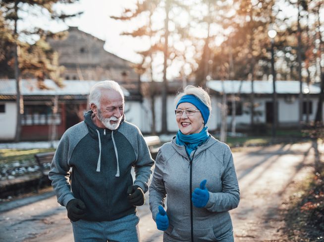 Senior couple running outside in the winter