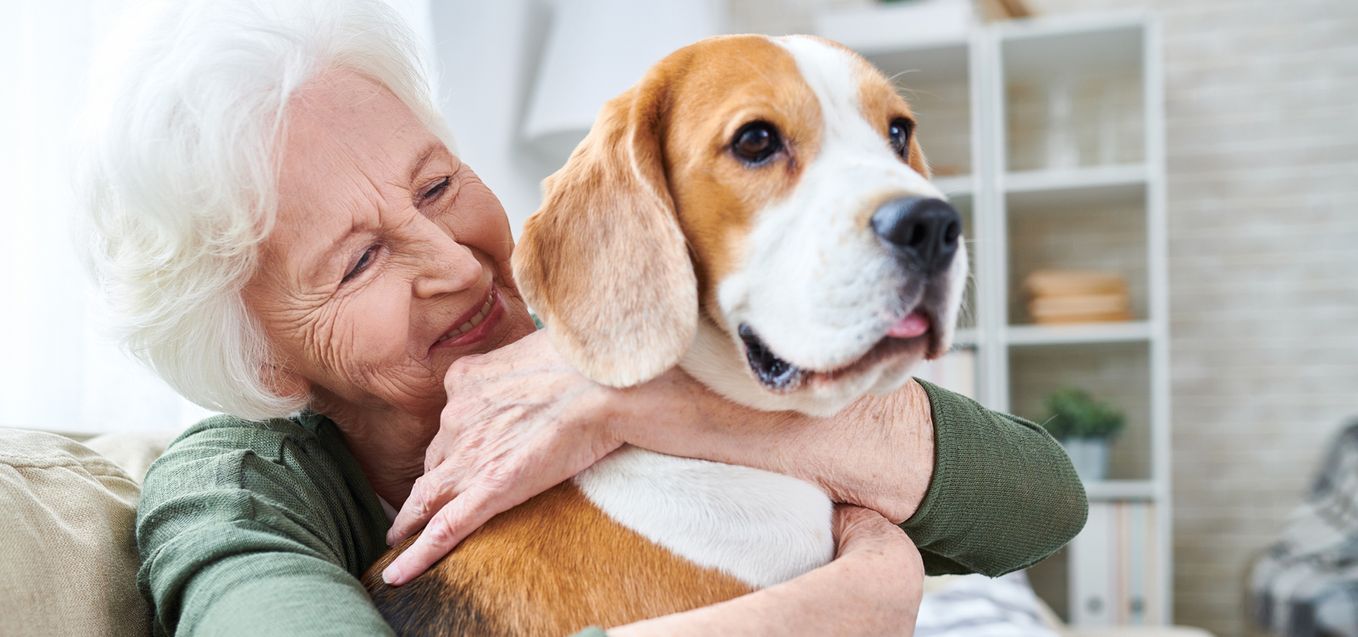 Senior woman hugging dog