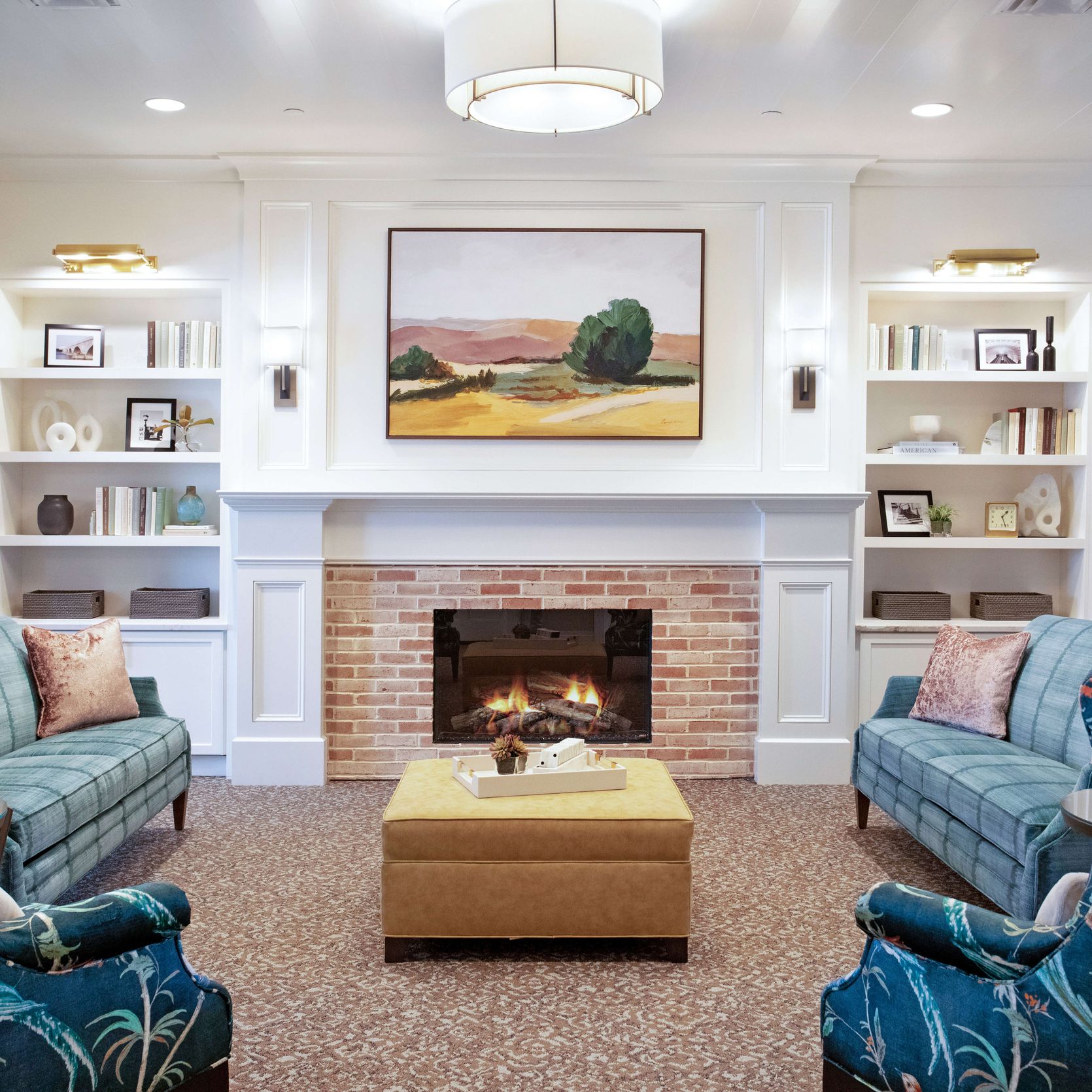 Living area at Senior Living Community with loveseats, couches, and a fireplace for residents